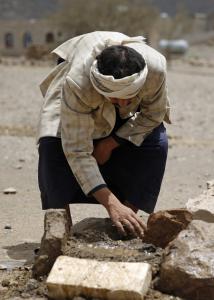 In this Monday, March 28, 2016 photo, Faisal Ahmed, whose son, Udai Faisal, died of severe acute malnutrition, tends to his grave in Hazyaz village, on the southern outskirts of Sanaa, Yemen. Hunger has been the most horrific consequence of Yemenís conflict and has spiraled since Saudi Arabia and its allies, backed by the U.S., launched a campaign of airstrikes and a naval blockade a year ago. (AP Photo/Hani Mohammed)