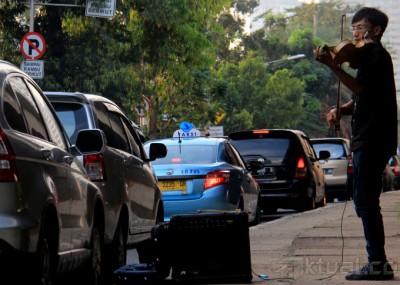 Mainkan Biola, Pemuda ini Hibur Warga Jakarta yang Terkena Macet