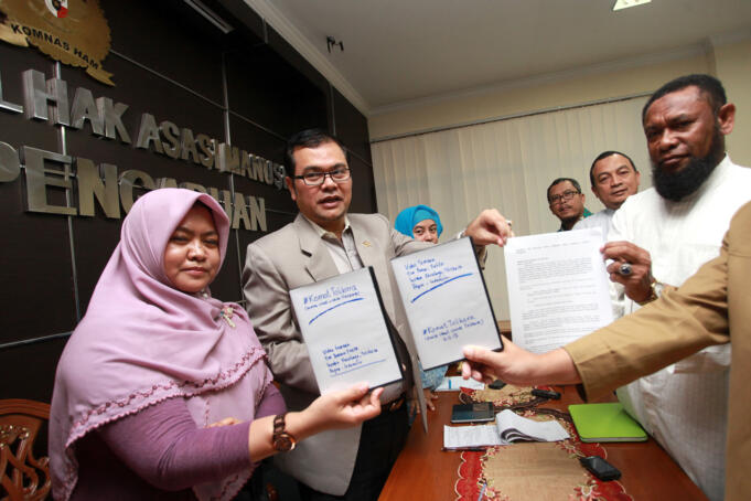 Tim Pencari Fakta (TPF) Komat Tolikara Fadlan Garamatan (kanan), Bachtiar Nasir (kedua kanan) dan Jeje Zaenudin (ketiga kanan) menyerahkan barang bukti kepada Anggota Komnas HAM Manager Nasution (kedua kiri) saat melaporkan hasil temuan insiden pembakara