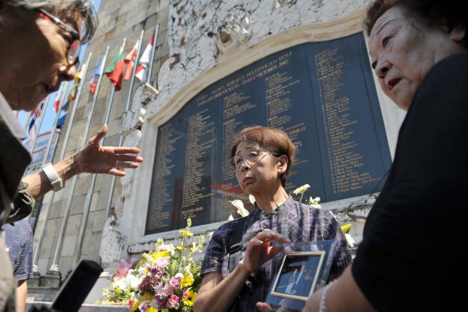 Keluarga korban bom Bali asal Jepang memegang foto anggota keluarganya yang menjadi korban bom saat hadir untuk mengenang 13 tahun tragedi bom Bali I di Monumen Bom Bali, Legian, Kuta, Bali, Senin (12/10).