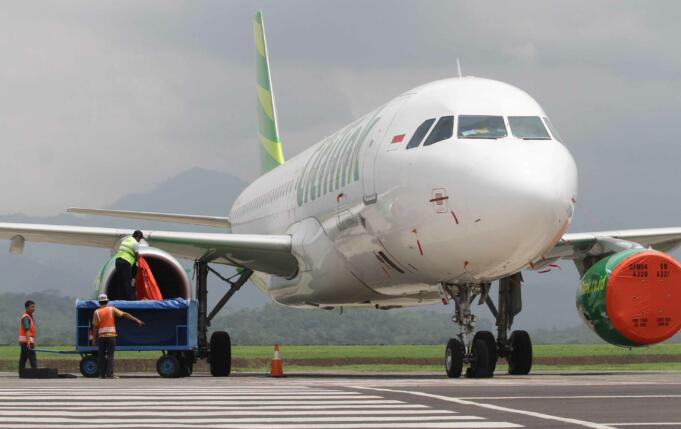 Petugas menutupi mesin pesawat dari abu vulkanik gunung Bromo di Bandara Abdul Rahman Saleh, Malang,