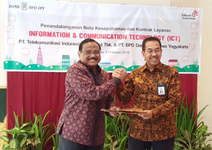 Direktur Enterprise Business Service Telkom Muhammad Awaluddin (kanan) dan Direktur Utama Bank BPD DIY Bambang Setiawan (kiri) bertukar naskah kerjasama usai penandatanganan nota kesepahaman Implementasi Layanan Information and Communication Technology (ICT) di Yogyakarta.