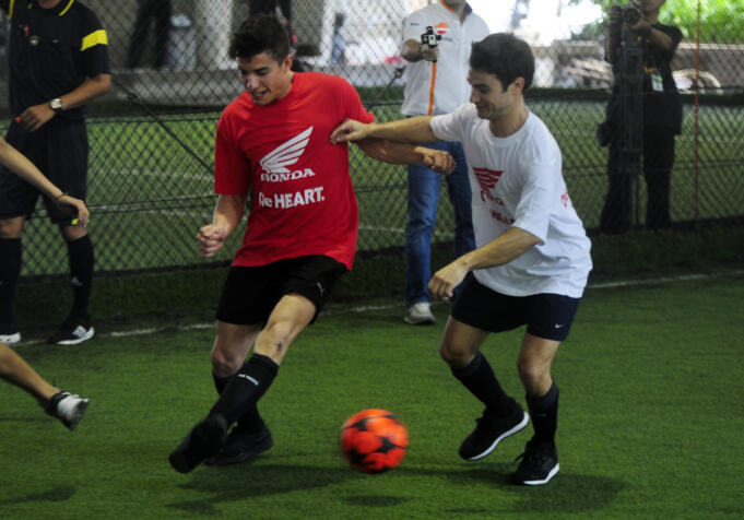 Pebalap Moto GP pabrikan Repsol Honda Marc Marquez (kiri) berebut bola dengan rekan setimnya Dani Pedrosa ketika bermain futsal di Jakarta, Sabtu (13/2).