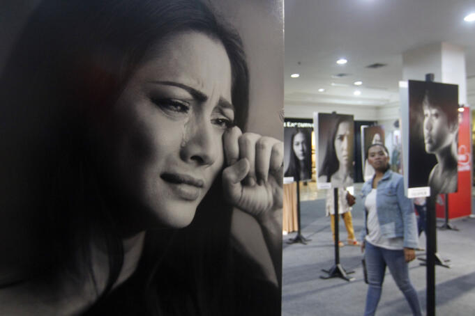 Seorang wanita melintas diantara foto-foto potret puluhan artis perempuan Indonesia dengan tema kampanye "Suara Hati" untuk menyuarakan anti kekerasan terhadap perempuan di Ambarukmo Plaza
