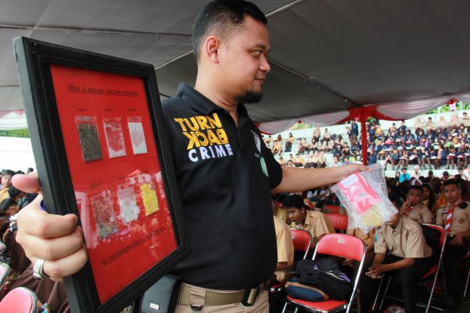 Seorang Anggota kepolisian menunjukan jenis dan macam-macam narkoba pada sejumlah siswa di Taman Blamdangan, Banyuwangi, Jawa Timur, Sabtu (27/2).