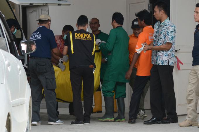 Petugas mengangkat kantong mayat salah satu dari dua jenazah teroris Poso yang baru tiba di Rumah Sakit Bhayangkara Palu, SulawesiTengah, Rabu (18/5).