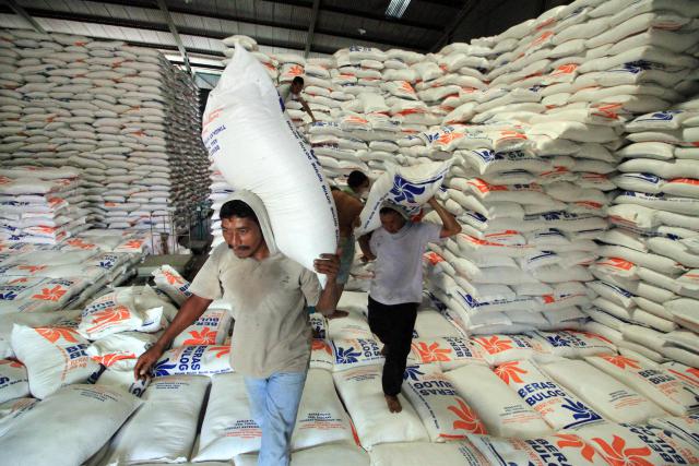 Sejumlah pekerja mengangkut karung beras untuk stok di gudang penyimpanan Sub Drive Regional Bulog Punteuet, Lhokseumawe, Aceh, Rabu (18/5)