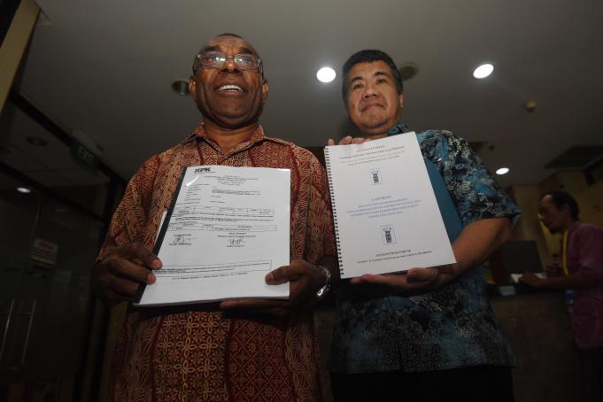 Mantan Wakil Bupati Fakfak, Papua Barat, Donatus Nimbitkendik (kiri) didampingi Direktur PASTI Indonesia Susanto menunjukkan bukti laporan dugaan korupsi HUT Kabupaten Fakfak di Gedung KPK, Jakarta, Kamis (12/5)