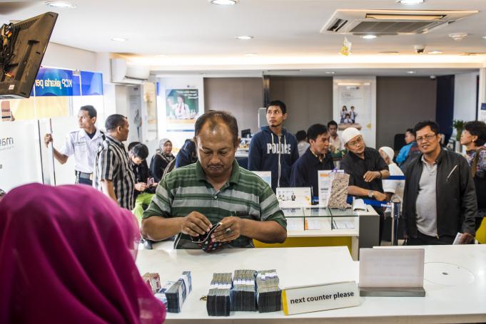Sejumlah nasabah mengantri untuk bertransaksi di Bank Mandiri KCP Jakarta Pertamina UPMS III, Jakarta, Jumat (6/5)