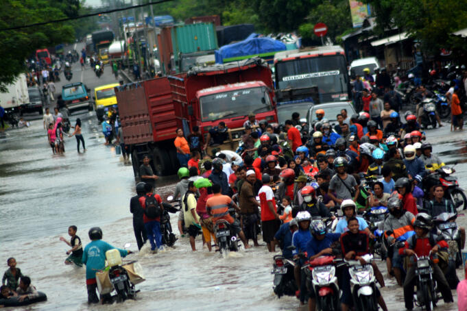 Puluhan truk dan kendaraan bermotor terjebak antrean akibat banjir yang menggenangi kawasan Jalan Raya Pantura Kraton, Pasuruan, Jawa Timur, Kamis (30/6)