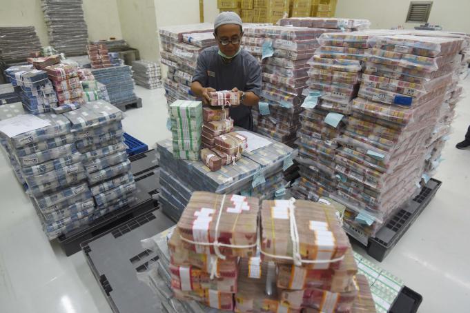 Petugas memindahkan uang di Cash Center Bank Negara Indonesia (BNI), Jakarta, Jumat (17/6)