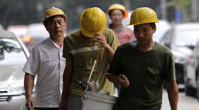 Workers walk toward a construction site in Beijing, August 28, 2014. China is confident of maintaining a medium-to-high rate of economic growth, Premier Li Keqiang was quoted by state television as saying on Tuesday. REUTERS/Jason Lee (CHINA - Tags: POLITICS BUSINESS SOCIETY)