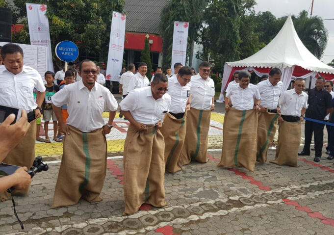 CEO Telkom Group Alex J. Sinaga (tengah), Direktur Utama Telkomsel Ririek Ardiansyah (paling kiri), Asisten Deputi Layanan Hukum Kementerian BUMN Dwi Ary Purnomo (ketiga kiri) membuka rangkaian lomba HUT RI ke 71 dengan Balap Karung di lapangan Telkom Regional V, Surabaya (17/8). Upacara Peringatan HUT RI ke 71 yang ditutup dengan lomba-lomba khas 17an menjadi acara puncak dari rangkaian program BUMN Hadir untuk Negeri.