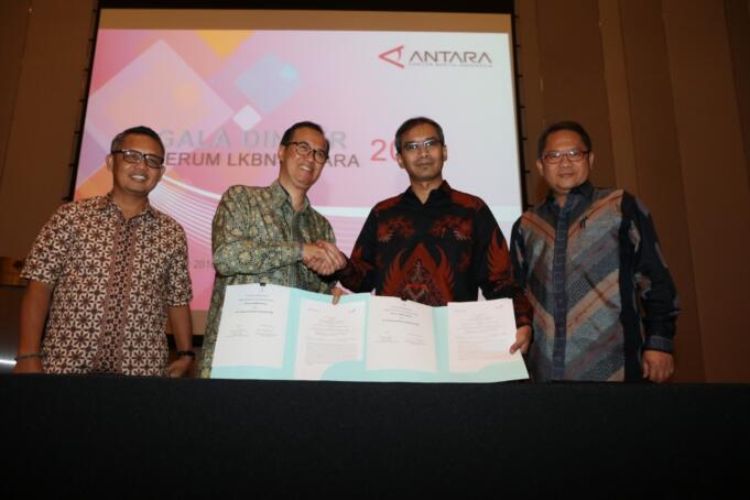 Direktur Digital & Strategic Portfolio Telkom Indra Utoyo (kedua kiri) dan Direktur Utama Perum LKBN Antara Meidyatama Suryodiningrat (kedua kanan) berjabat tangan usai penandatanganan sinergi Telkom dan LKN Antara didampingi Menteri Komunikasi dan Informatika RI Rudiantara (kanan) dan Kepala Bidang Pertambangan Industri Strategis dan Media Kementerian BUMN Mahmud Husein di Jakarta, Rabu (5/10).