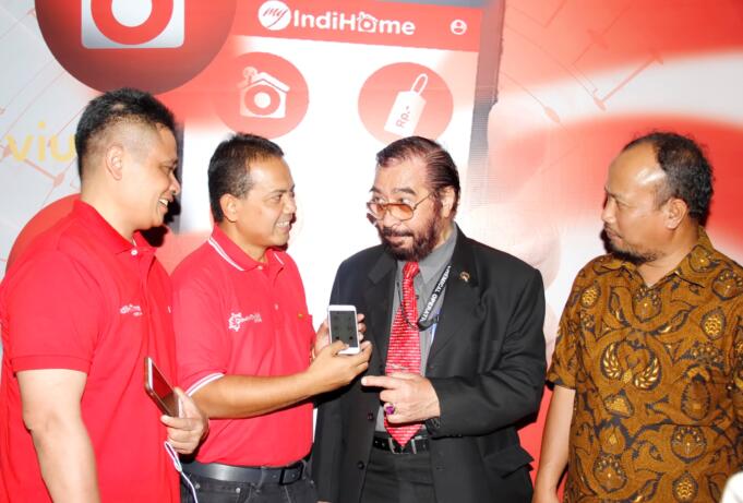 Direktur Consumer Service Telkom Dian Rachmawan (kiri), menyaksikan Executive Vice President Telkom Regional II Teuku Muda Nanta (kedua kiri) menjelaskan aplikasi ‘My IndiHome’ pada smartphone kepada salah seorang pelanggan, disaksikan Ketua Yayasan Lembaga Konsumen Indonesia (YLKI) Tulus Abadi, disela Gathering pelanggan IndiHome, di Jakarta, Sabtu (10/12).