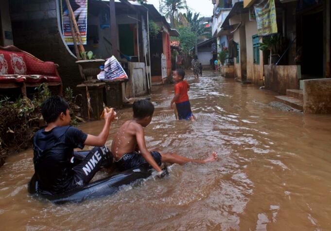 Sejumlah anak-anak bermain banjir yang berada di kampung Bayur di RW 04 Cipinang Melayu, Jakarta Timur, Minggu (26/2/2017), kembali terendam banjir. Air yang menggenangi kawasan tersebut setinggi lebih dari 30 centimeter, diduga akibat dari kali sunter . Namun sejumlah anak-anak terlihat senang memanfaatkan banjir untuk bermain air. AKTUAL/Munzir