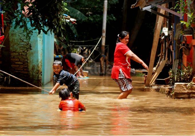 Sejumlah anak-anak bermain banjir yang berada di kampung Bayur di RW 04 Cipinang Melayu, Jakarta Timur, Minggu (26/2/2017), kembali terendam banjir. Air yang menggenangi kawasan tersebut setinggi lebih dari 30 centimeter, diduga akibat dari kali sunter . Namun sejumlah anak-anak terlihat senang memanfaatkan banjir untuk bermain air. AKTUAL/Munzir