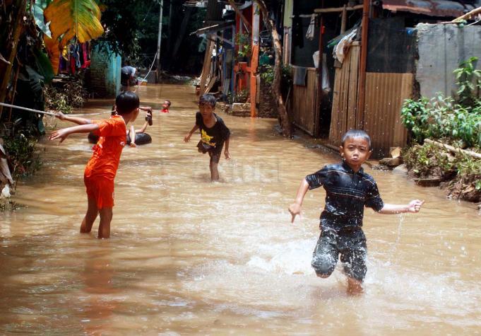 Sejumlah anak-anak bermain banjir yang berada di kampung Bayur di RW 04 Cipinang Melayu, Jakarta Timur, Minggu (26/2/2017), kembali terendam banjir. Air yang menggenangi kawasan tersebut setinggi lebih dari 30 centimeter, diduga akibat dari kali sunter . Namun sejumlah anak-anak terlihat senang memanfaatkan banjir untuk bermain air. AKTUAL/Munzir