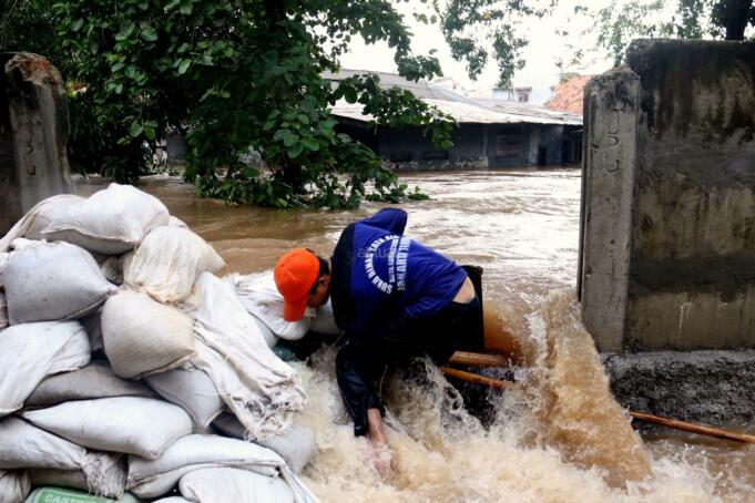 Sejumlah petugas Dinas Tata Air DKI Jakarta berjibaku menutup tanggul yang jebol Kali Sunter yang berada di belakang Perumahan Cipinang Indah, Jakarta Timur, Selasa (21/2/2017). Tembok yang juga menjadi tanggul Kali Sunter di kawasan Cipinang Indah jebol akibat tak mampu menahan besarnya debit air yang melintas. Hasilnya, kawasan Jakarta Timur terendam banjir. AKTUAL/Munzir
