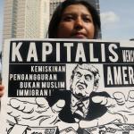 Sejumlah masa yang tergabung dalam front Perjuangan Rakyat membentangkan spanduk dan membawa poster saat melakukan aksi yang mengecam kebijakan Presiden Amerika Serikat Donald Trump di kawasan Bunderan HI, CFD, Jakarta, Minggu (5/2/2017). Dalam aksinya mereka mendesak agar Presiden Donald Trump mencabut kebijakan yang merugikan imigran muslim. AKTUAL/Munzir