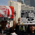 Sejumlah masa yang tergabung dalam front Perjuangan Rakyat membentangkan spanduk dan membawa poster saat melakukan aksi yang mengecam kebijakan Presiden Amerika Serikat Donald Trump di kawasan Bunderan HI, CFD, Jakarta, Minggu (5/2/2017). Dalam aksinya mereka mendesak agar Presiden Donald Trump mencabut kebijakan yang merugikan imigran muslim. AKTUAL/Munzir