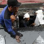 Pekerja Dinas Kebersihan Provinsi DKI Jakarta memberishkan gorong-gorong di Jalan Gatot Subroto, Jakarta, Selasa (14/3). Pembersihan gorong-gorong ini dilakukan sebagai tindak lanjut penemuan sampah kabel listrik yang menyumbat saluran air di Jalan Gatot Subroto hingga mengakibatkan banjir beberapa hari lalu. AKTUAL/Tino Oktaviano