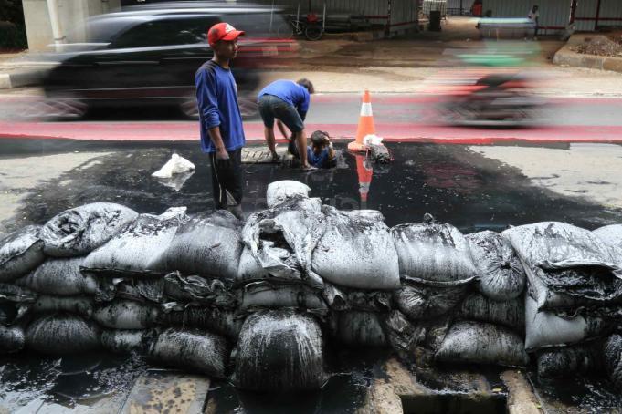 Pekerja Dinas Kebersihan Provinsi DKI Jakarta memberishkan gorong-gorong di Jalan Gatot Subroto, Jakarta, Selasa (14/3). Pembersihan gorong-gorong ini dilakukan sebagai tindak lanjut penemuan sampah kabel listrik yang menyumbat saluran air di Jalan Gatot Subroto hingga mengakibatkan banjir beberapa hari lalu. AKTUAL/Tino Oktaviano