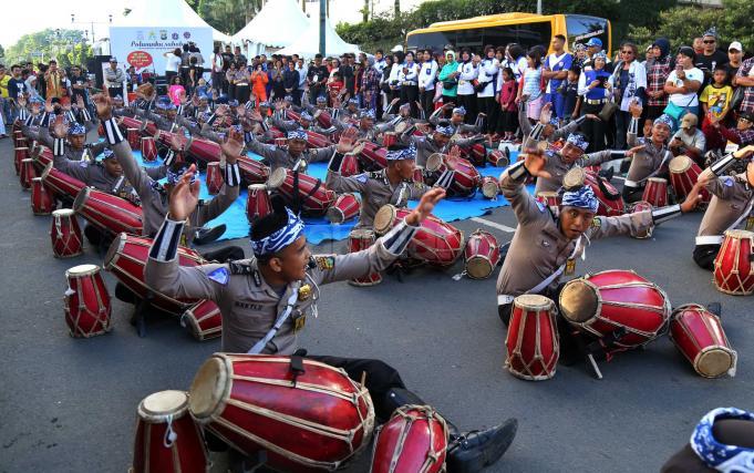 Sejumlah polisi menampilkan atraksi kesenian Rampak Gendang menhibur warga di Car Free Day kawasan Bundaran HI, Jakarta, Minggu (9/4). Aksi rampak gendang ini dalam rangka sosialisasi Polwanku, Sahabatku menemani sepanjang perjalanan kesekolah. Untuk kedepannya setiap angkutan bus sekolah gratis dan aman akan didampingi dua polwan selama perjalanan menuju sekolah. AKTUAL/Tino Oktaviano
