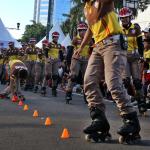Polisi patroli sepatu roda menampilkan atraksi di area Car Free Day di Bundaran HI, Jakarta, Minggu (9/4). Patroli polisi ini dilakukan untuk menjaga ketertiban serta keamanan bagi warga yang berolahraga. AKTUAL/Tino Oktaviano