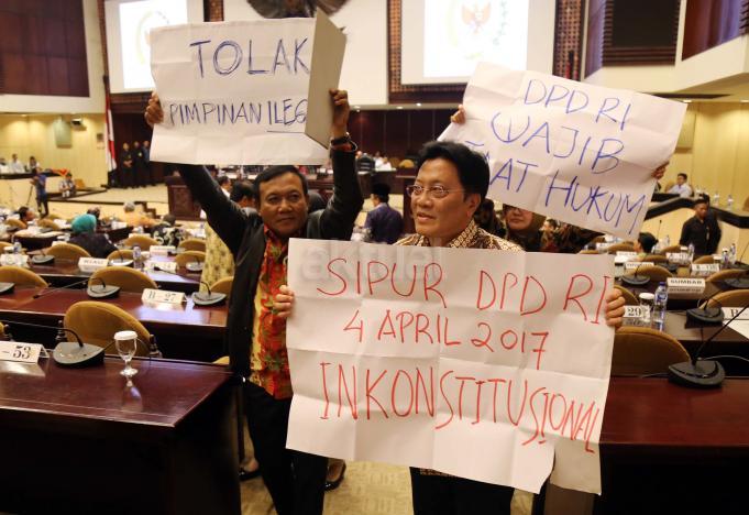 Sejumlah anggota DPD membentangkan poster saat sidang paripurna DPD di GEdung Nusantara V, Komplek Parlemen Senayan, Jakarta, Selasa (11/4). Sejumlah anggota sempat melancarkan protes yang lebih keras. Mereka membawa karton putih dengan berbagai macam tulisan penolakan. AKTUAL/Tino Oktaviano