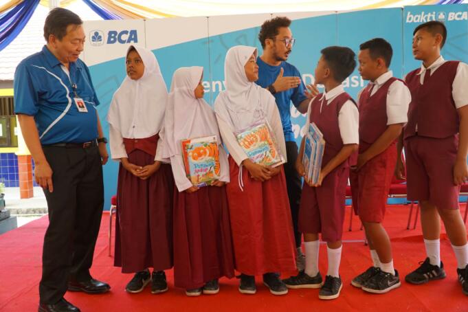 Direktur BCA Santoso (kiri) dan Musisi Nidji, Giring Ganesha (kanan), berdialog dengan siswa SD Negeri 7 Gadingrejo, usai menyerahkan donasi buku melalui program Gerakan Berbagi Buku untuk Indonesia, di Bandar Lampung, Lampung, Jumat (21/7). BCA mengumpulkan dana dari nasabah Rp1,05 miliar yang kemudian diwujudkan dalam bentuk buku yang didonasikan ke 104 sekolah penerima di 60 titik di Indonesia