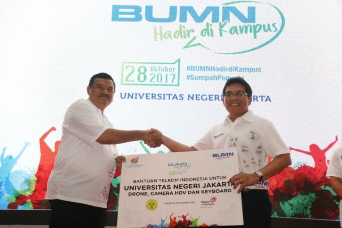 Direktur Utama Telkom Alex J. Sinaga (kanan) menyerahkan simbolis Telkom yang diterima oleh Wakil Rektor III Universitas Negeri Jakarta (UNJ) Achmad Sofyan Hanif (kiri) pada acara BUMN Hadir di Kampus dalam rangka memperingati Hari Sumpah Pemuda, Sabtu (28/10).