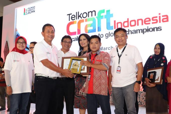 Deputi Bidang Usaha Jasa Keuangan, Jasa Survei, dan Konsultan Kementerian BUMN RI Gatot Tri Hargo (kedua dari kiri) bersama dengan Komisaris Utama Telkom Hendri Saparini (paling kiri), Direktur Utama Telkom Alex J. Sinaga (ketiga dari kiri), Direktur Utama Telkomsel Ririek Adriansyah (kedua dari kanan) dan Ketua Umum Forsikatel Evelita Sinaga (ketiga dari kanan) menyerahkan penghargaan "Best of The Best Telkom Craft 2018" kepada UKM Suke Clothing (ketiga dari kanan) saat acara closing ceremony Telkom Craft Indonesia 2018 di Jakarta (25/3).