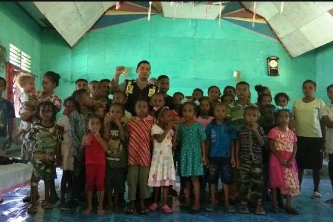 Briptu Ramayadi Drakel berpose bersama anak-anak sekolah minggu di Gereja GPDP Syaloom, Kampung Karoaipi, Distrik Teluk Ampimoi, Kabupaten Kepulauan Yapen, Papua, Minggu. (ANTARA /HO-Humas Polda Papua)