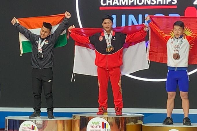 Lifter Indonesia Muhammad Faathir menaiki podium setelah meraih medali emas pada kejuaraan angkat besi junior dan remaja di Tashkent, Uzbekistan, Sabtu (15/2/2020). (ANTARA/HO/PB PABBSI)