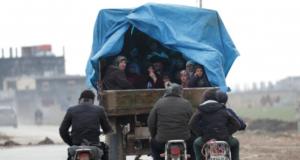 Warga yang mengungsi, meninggalkan Idlib, berada di atas truk dengan harta benda mereka di Azaz, Suriah