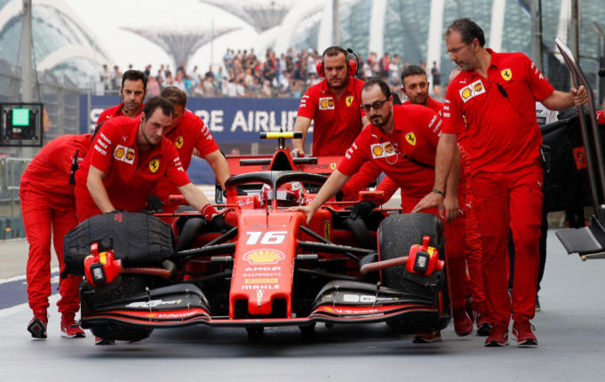 Tim Scuderia Ferrari sedang mendorong mobil Charles Leclerc di daerah pitstop Grand Prix Singapura pada 22 September lalu | REUTERS/Tim Chong