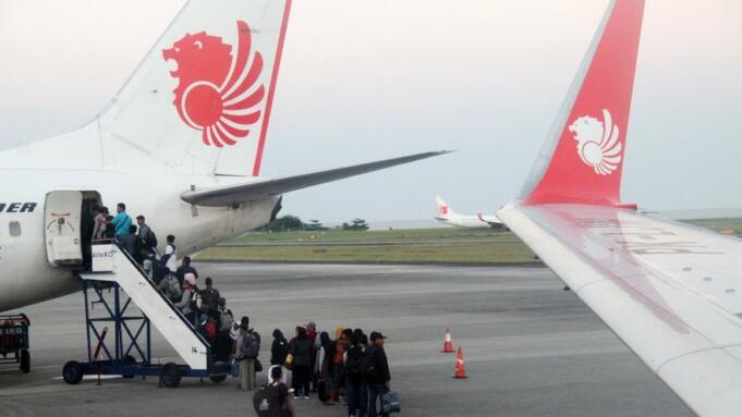 Sejumlah calon penumpang antre naik ke pesawat maskapai Lion Air