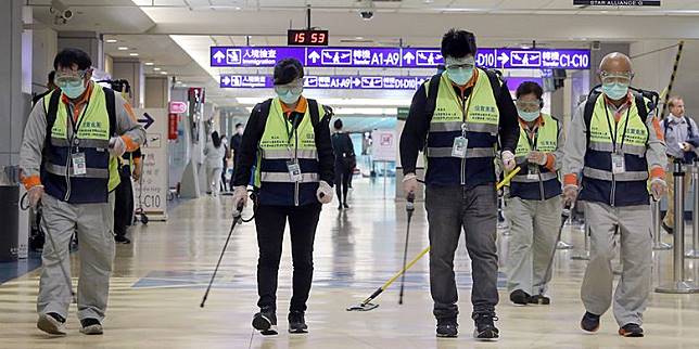 Pekerja bermasker melakukan kegiatan desinfeksi di area Bandara Internasional Taoyuan, Taiwan