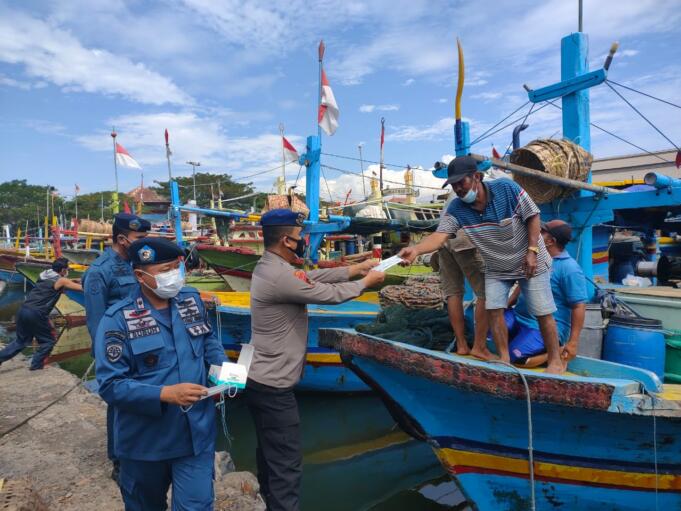 Anggota Polairud dan KSOP Kelas IV Probolinggo saat mengimbau nelayan dan bagikan masker/foto: Istimewa