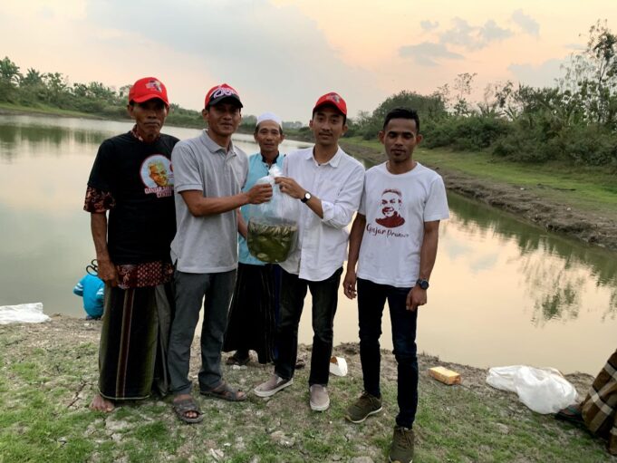 Sukarelawan Ganjar Milenial bersiap melepaskan bibit ikan nila ke dalam waduk di Desa Cengkir, Kecamatan Kepohbaru, Kabupaten Bojonegoro, Jawa Timur