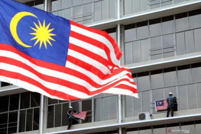 Para pekerja menggantung bendera Malaysia menjelang perayaan 62 tahun kemerdekaan negara tersebut pada tanggal 31 Agustus di Kuala Lumpur, Malaysia, Rabu (31/7/2019).
