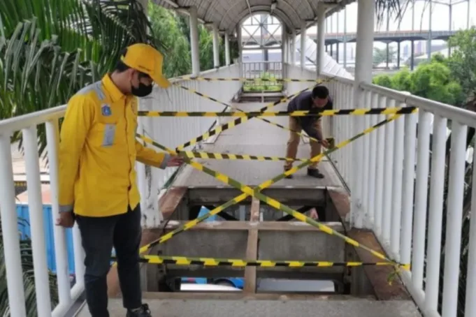 Petugas Sudin Bina Marga Jakarta Barat memasang garis pengaman pada JPO Warung Gantung di Semanan, Kalideres, Jakarta Barat, Senin (7/8/2023). ANTARA/HO-Sudin Bina Marga Jakbar