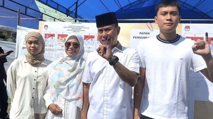 Andi Sumangerukka bersama istri dan anaknya menyalurkan hak pilihnya pada Pilkada 2024 di Kota Kendari, Rabu (27/11/2024). (sumber: TribunnewsSultra.com)