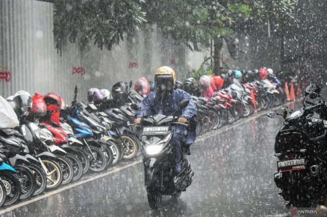 Pengendara sepeda motor menerobos hujan di kawasan Senopati, Jakarta,