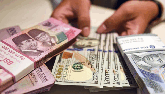 Ilustrasi - Petugas menunjukan uang pecahan dolar AS dan rupiah di Bank BSI, Jakarta. ANTARA FOTO/Muhammad Adimaja