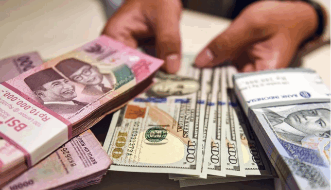 Ilustrasi - Petugas menunjukan uang pecahan dolar AS dan rupiah di Bank BSI, Jakarta. ANTARA FOTO/Muhammad Adimaja