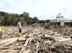 Alam yang Murka, Manusia yang Lalai Relawan bencana melihat tumpukan gelondongan kayu di belakang masjid Nurussalam, Desa Lubuk Sidup, Aceh Tamiang, Aceh, Minggu (28/12/2025). Bencana banjir bandang akibat luapan sungai Tamiang pada 26 November 2025 mengakibatkan 200 unit lebih rumah warga rusak berat dan hanya menyisakan bangunan masjid Nurussalam di Desa Lubuk Sidup. ANTARA FOTO/Irwansyah Putra/foc. (ANTARA FOTO/IRWANSYAH PUTRA)