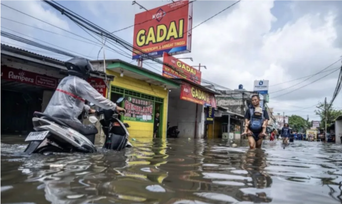 Warga melintasi banjir yang merendam perkampungan di Rawa Buaya, Cengkareng, Jakarta Barat, Sabtu (24/1/2026). (ANTARA FOTO/Bayu Pratama S/nz.)