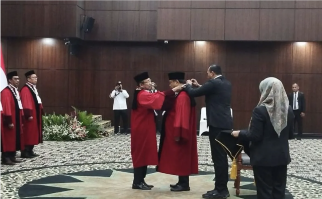 Pelepasan kalung Hakim Konstitusi MK Arief Hidayat oleh Ketua Hakim Konstitusi MK Suhartoyo dalam acara wisuda purnabakti di Gedung Sidang Pleno I MK, Jakarta, Rabu (4/1/2026). (ANTARA/Muhammad Rizki)